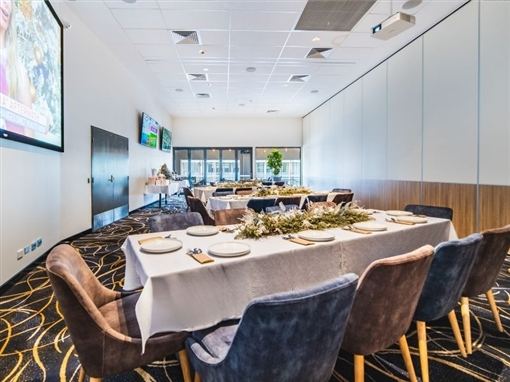The Great Western Function Room set for a dinner, with a large screen